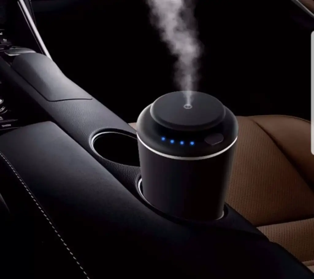 The TMS F1 Black Aroma Diffuser sitting in a car's cupholder.