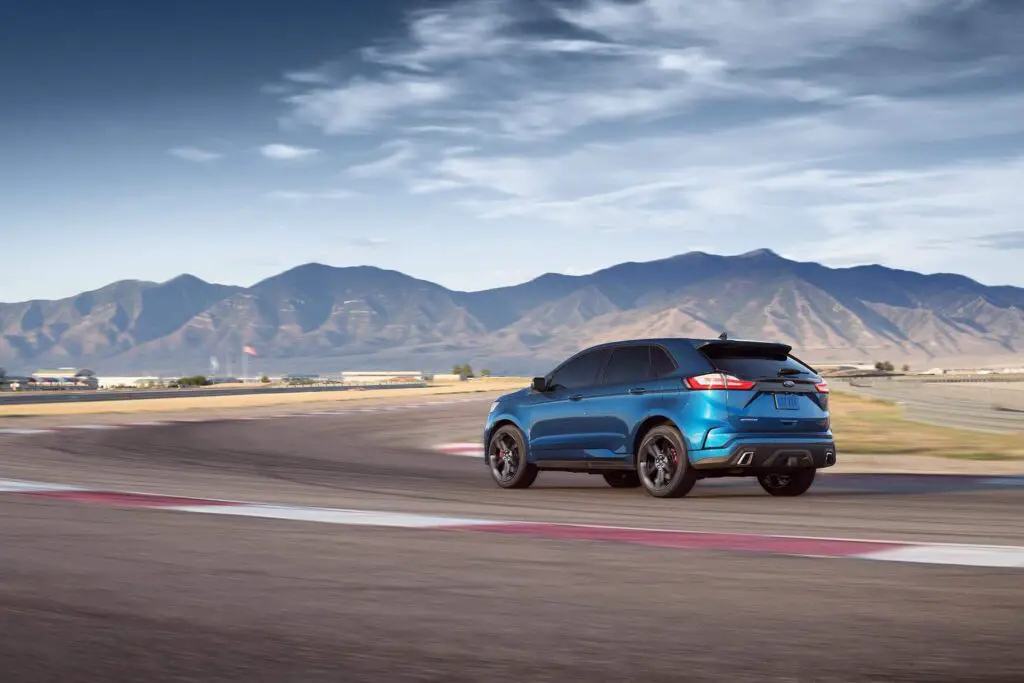 The 2020 Ford Edge ST AWD on a track by the mountains.