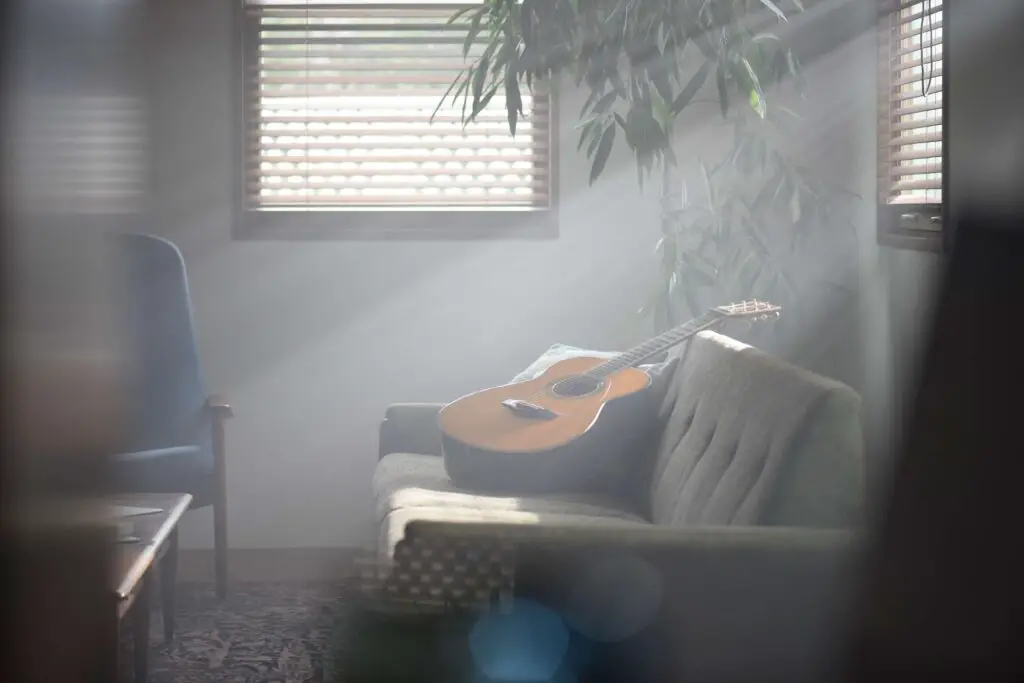 The Yamaha LS-TA TransAcoustic guitar bathed in sunlight on a couch.