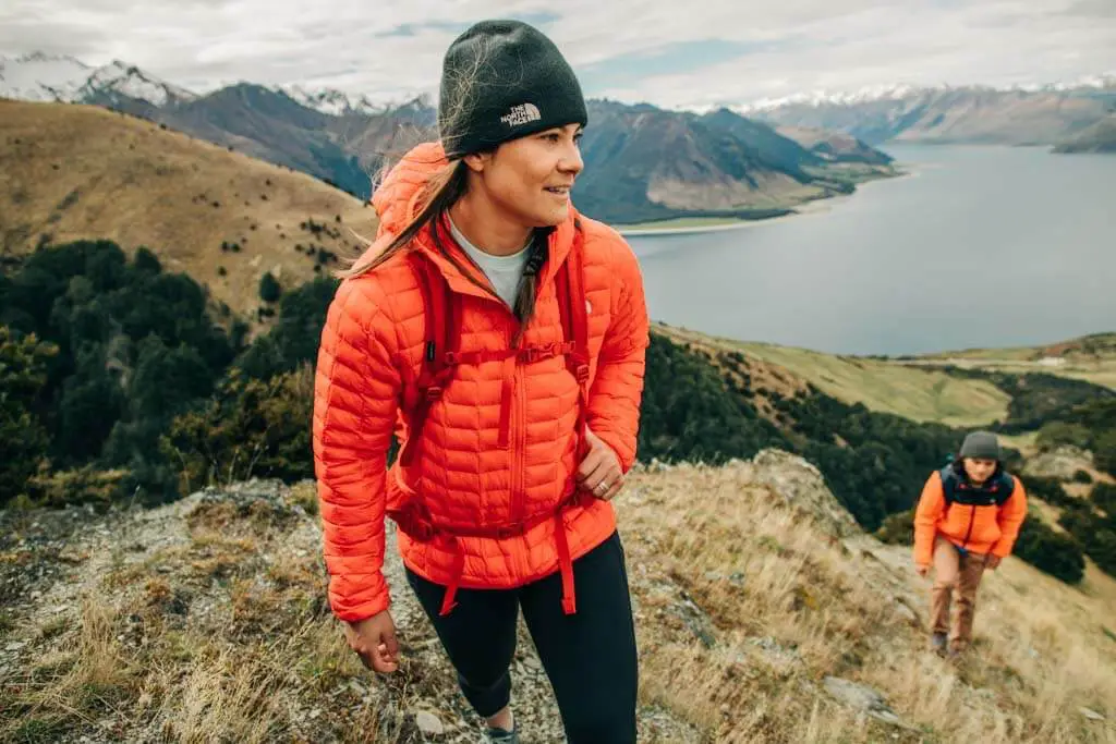 A woman wearing her women's Thermoball Eco Hoodie as she hikes up a mountain.