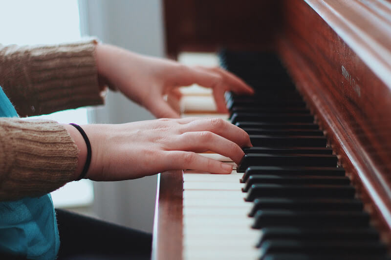 A close-up of a girl's hands as she plays piano