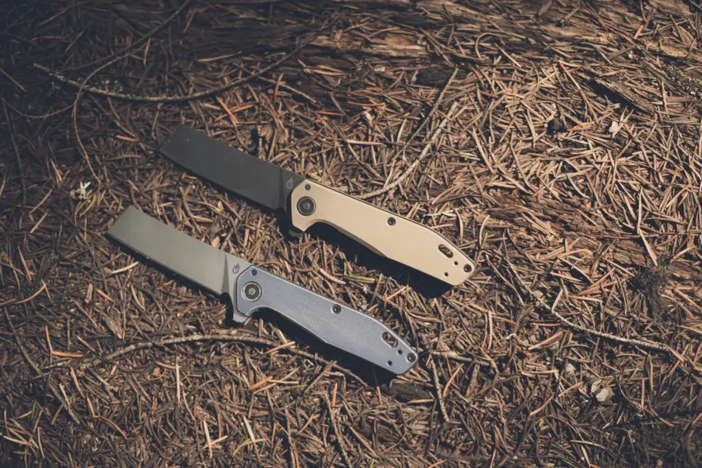Two Gerber Fastball Cleaver knives laying on the forest floor.