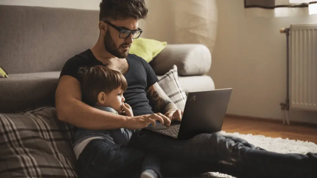 A father and son using their Lenovo ThinkPad X1 Nano computer while cuddled close together.
