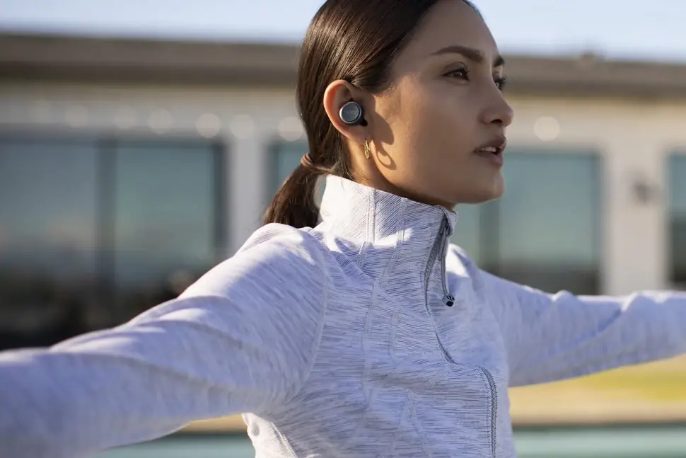 woman working out using wireless earbuds from Cleer Audio noise cancelling