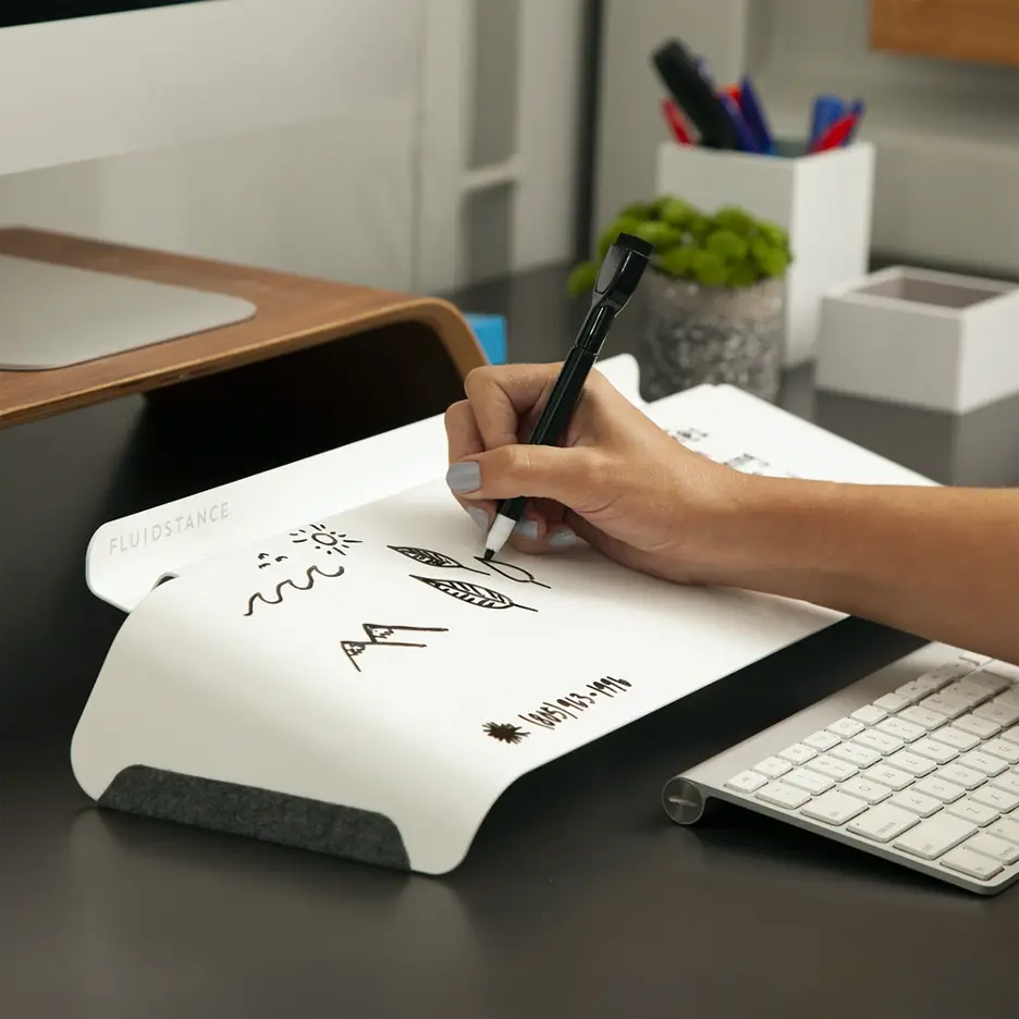woman writing notes on FluidStance Slope whiteboard on desk office products