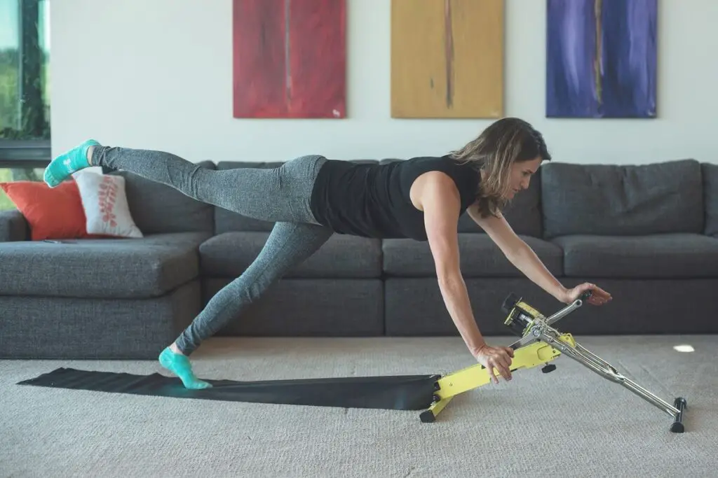 A woman using the Ecxy 240 Peloton System in her living room.