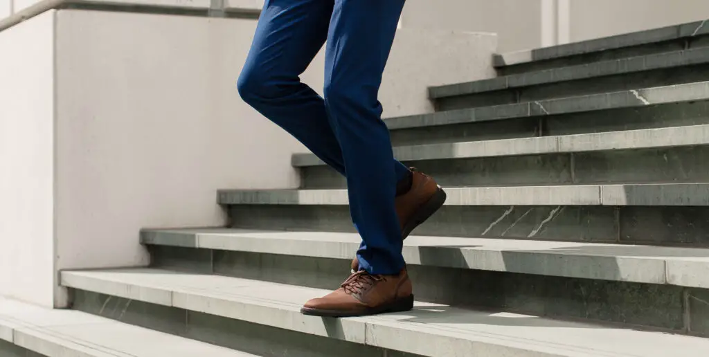 A man walking down the stairs wearing his Third Mind shoes.