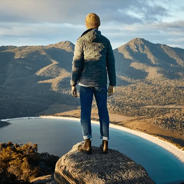 A woman wearing her Blundstone boots on the top of a mountain.