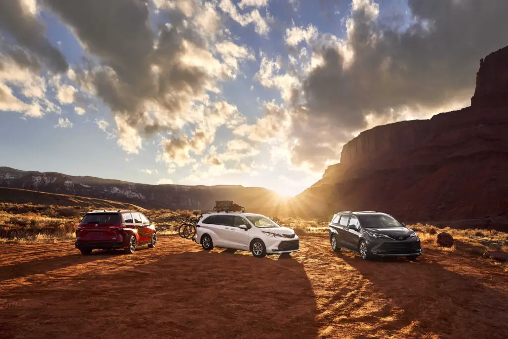 Three Toyota Siennas out in an Arizona desert during a beautiful sunset.