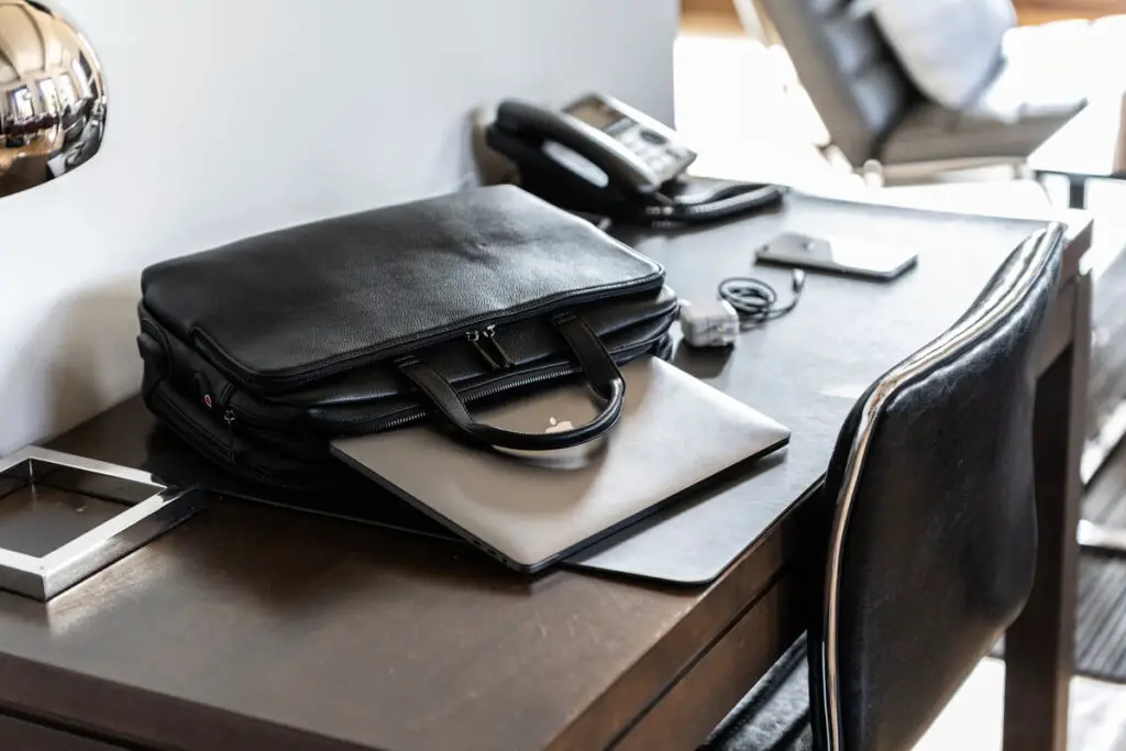 The Kanevas Benjamin bag holding a computer while placed on a desk.