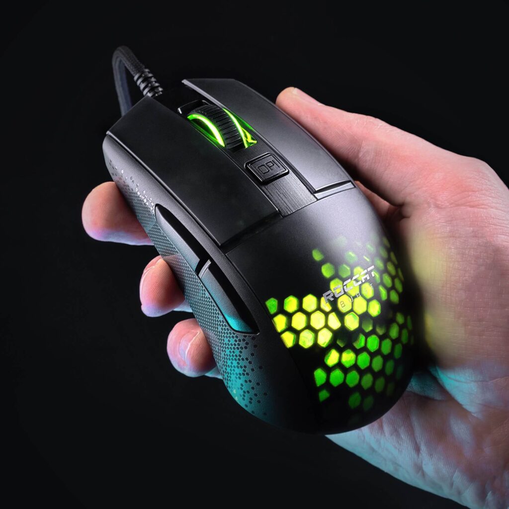 A man holding the Roccat Bust Pro mouse in his hand as it lights up a honeycomb pattern of vibrant green and yellow.