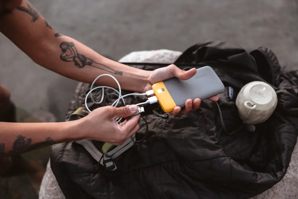 A person plugging their devices into the BioLite Portable Charger.