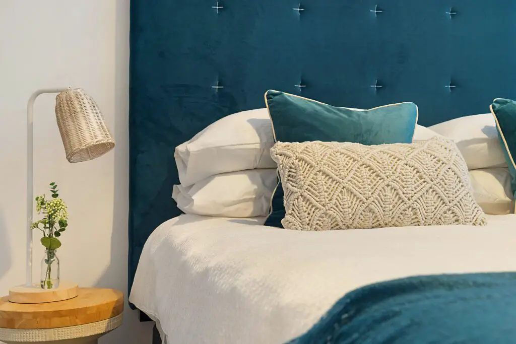 blue bed and mattress with pillows and the Brooklinen Luxe Core sheet set.