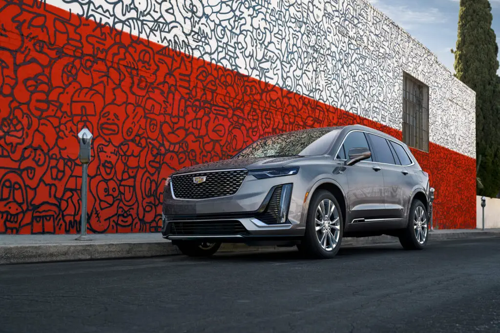 The 2021 Cadillac XT6 parked next to a bright red and white mural.